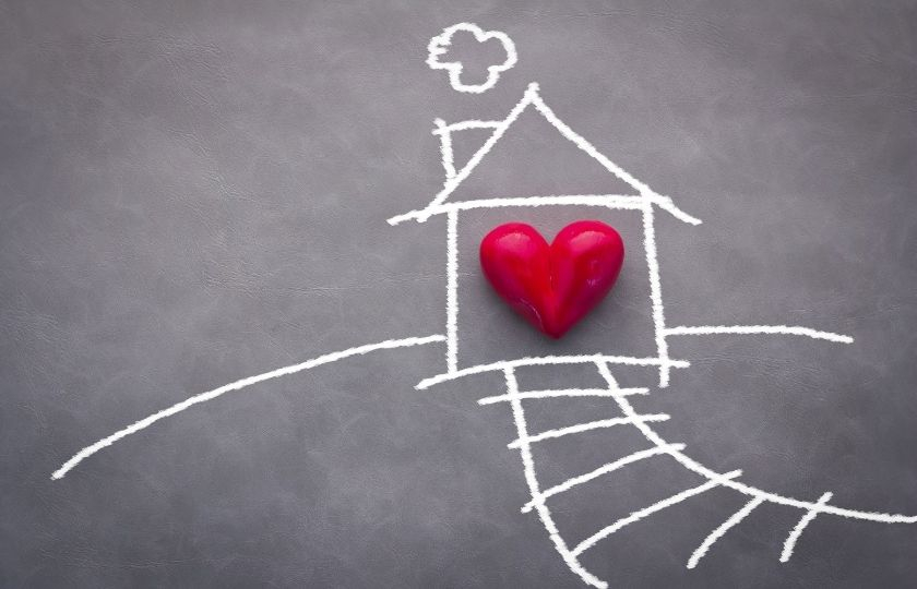 chalk drawn house on a grey background. A heart is at the centre