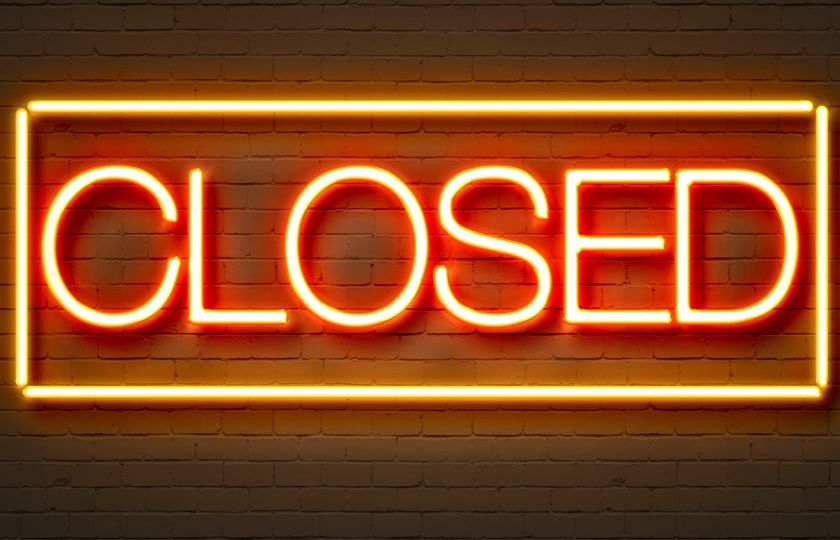 Text saying 'closed'. Text appears a lit sign against a dark wood background