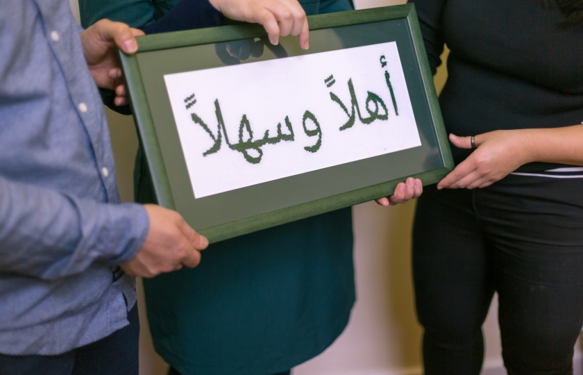 Framed cross-stitch of 'Welcome' in Arabic