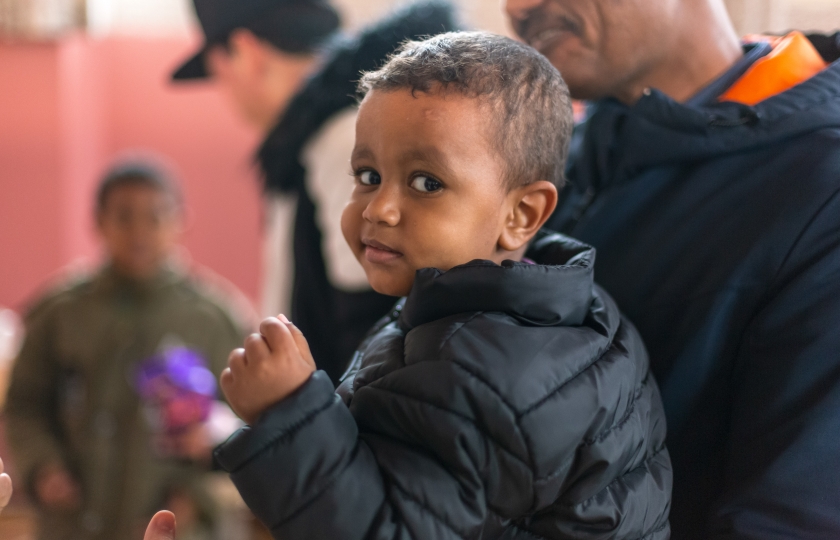 Young boy held in his father's arms