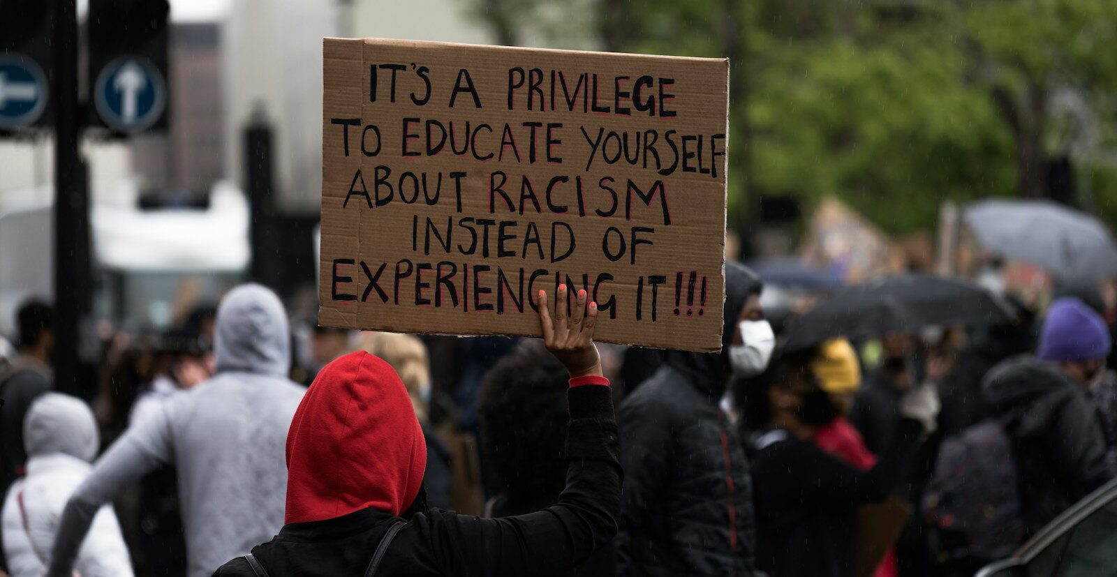 people holding brown wooden signage during daytime